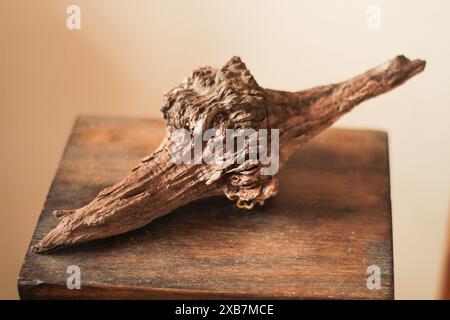 A wooden plank on a table next to a vase of flowers Stock Photo