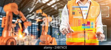 Technician or engineer work with robotic arms in factory Stock Photo