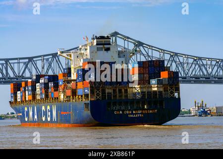 Huge and fully loaded container ship approaching  Crescent City Connection bridges on the MIssissippi River, New Orleans, Louisiana, USA. Stock Photo