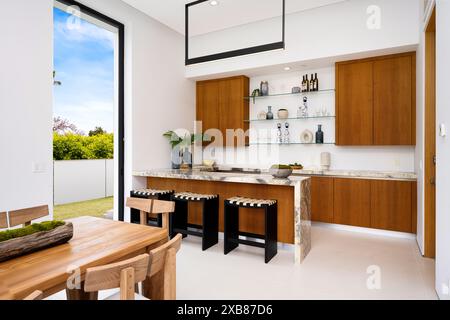 A Contemporary kitchen with dining area and bench seating in a sunlit room Stock Photo