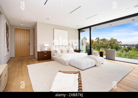 A Modern bedroom with sliding glass doors offering scenic views of the landscape Stock Photo