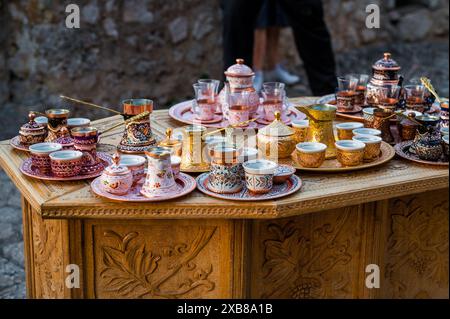 Traditional handmade souvenir from Bosnia and Herzegovina - turkish coffee pot with small copper cups. Bosnian coffee sets in the bazaar. Stock Photo