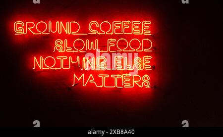 Glowing red neon letters on the wall, ground coffee, slow food, nothing else matters Stock Photo