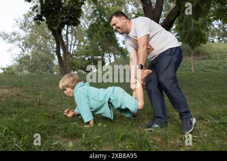 Dad and son are actively having fun in nature. family together on vacation. Stock Photo