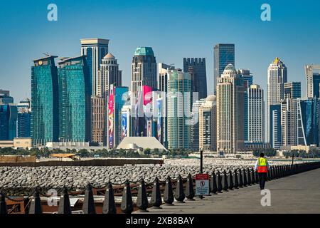 A construction worker on waterfront road with skyskrapers in background Stock Photo