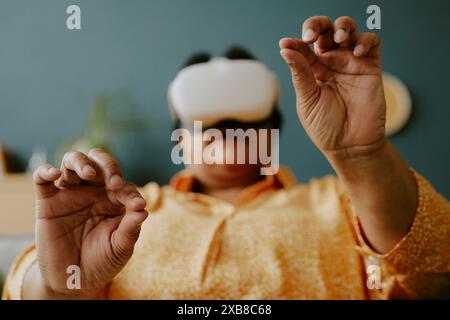 African American female gamer holding invisible things while playing VR game Stock Photo
