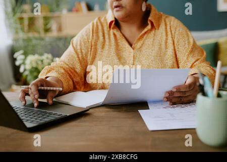 Mature African American woman struggling with red tape during remote work Stock Photo