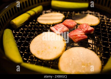 A charcoal grill with various foods sizzling on it Stock Photo