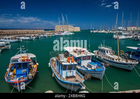 Fishing boats at Venetian Harbor, Rocca al Mare Venetian Fortress in distance, port in Heraklion (Iraklio, Iraklion), Central Crete, Greece Stock Photo