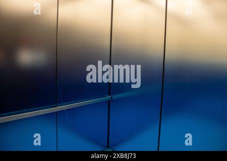 An illuminated metallic blue and silver wall Stock Photo