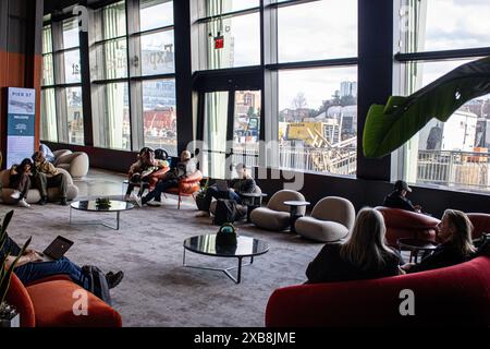 A diverse group sitting on chairs and working. Google Pier 57, New York Stock Photo