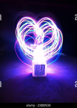 A glowing heart shape created by light painting on a screen Stock Photo