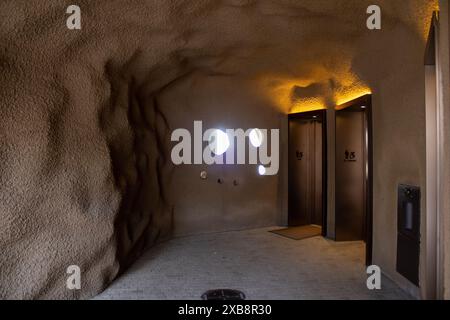 Multiple holes on a wall with two modern elevators beside it in an old building Stock Photo