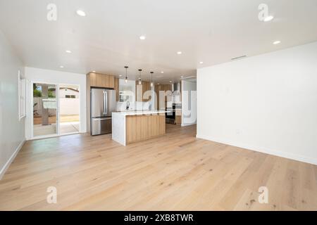 Minimalist kitchen and dining area with hardwood floors and white walls Stock Photo