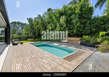 Backyard pool with adjacent lounge area Stock Photo