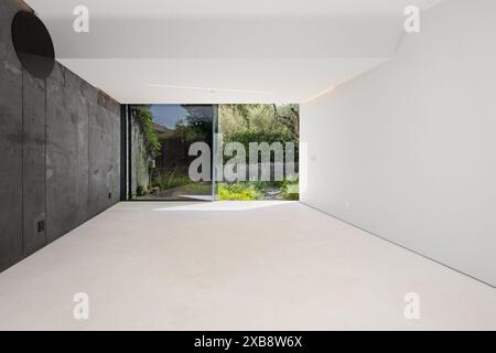 A room with concrete walls and sliding glass doors Stock Photo