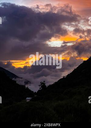 Dramatic sunset sky over mountain lake with dark clouds Stock Photo