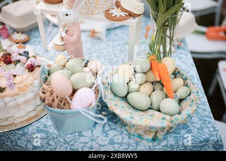 A table adorned with flowers, bunnies, and assorted Easter eggs Stock Photo