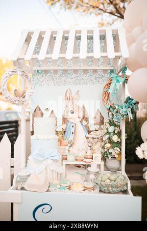 A vertical shot of an Easter-themed cake on a decorative stand with festive decorations Stock Photo