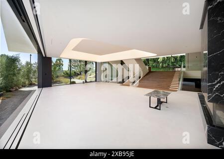 An Empty living room with stairs in the background and a marble bench on the side Stock Photo