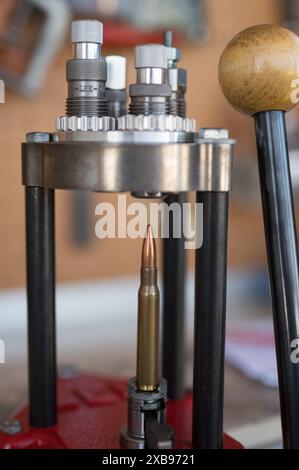 manual placement and introduction of the tip of the 30-06 or 7.62x63 caliber projectile with the press. jacketed and copper-plated tip, shielded Stock Photo