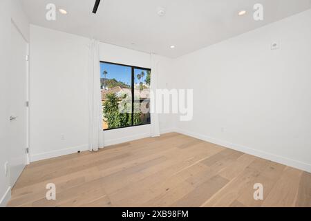 An empty room with white walls and a wooden floor. Home interior. California, USA Stock Photo