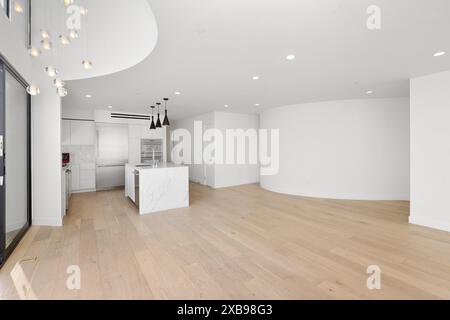 A spacious living room with a kitchen and wooden flooring. California, USA Stock Photo