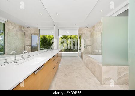 A spacious bathroom with dual sinks and modern walk-in shower Stock Photo