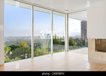 A Spacious living room with tall windows and hardwood floors Stock Photo