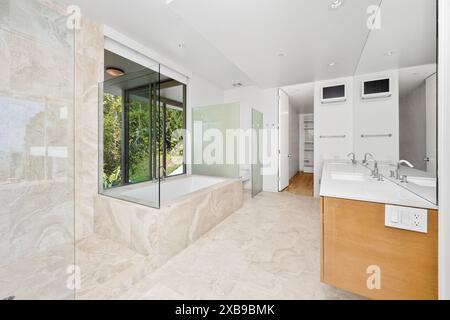 A white bathroom with beige tiles and glass shower Stock Photo