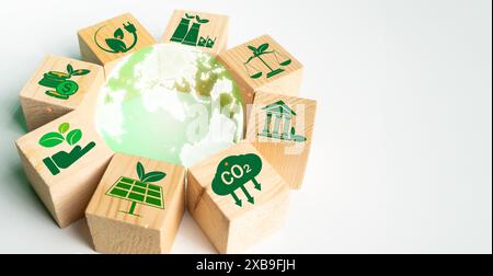 The globe is inside a glass globe surrounded by wooden blocks with eco-friendly campaign icons ,concept image of a campaign to reduce the amount of gr Stock Photo