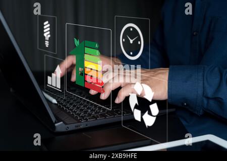 Home improvement concept, Hand of businessman using laptop with energy efficiency rating, ecological and bioenergetic house, efficiency scale. Stock Photo
