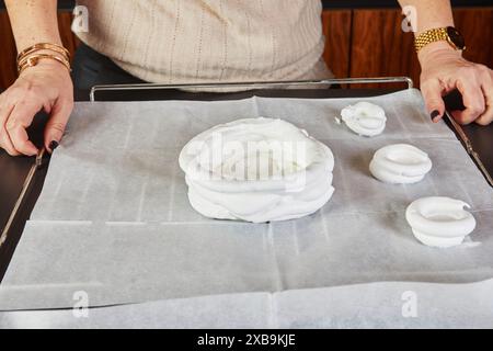 A home cook prepares meringue and places the cream on the board. Stock Photo