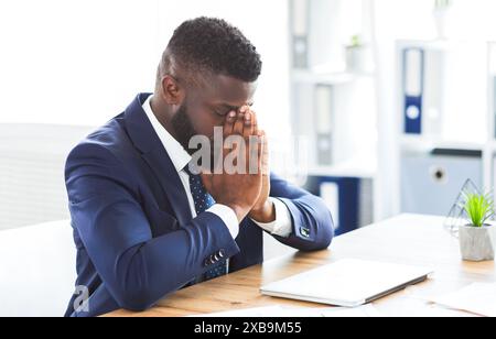Young tired businessman having stress at work Stock Photo