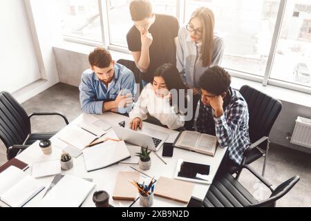 Group of People Sitting Around Table Looking at Laptop Stock Photo