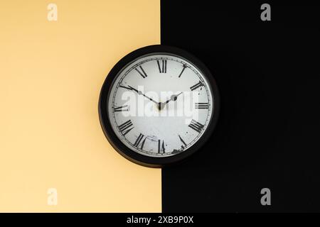 Vintage retro wall clock on black and beige background. Time concept. Minimal composition. Flat lay. Stock Photo