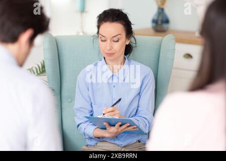 Counselor Engaging With Clients Spouses During Therapy Session in Clinic Stock Photo