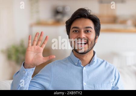 Happy Man Waving Hello in a Casual Setting Stock Photo
