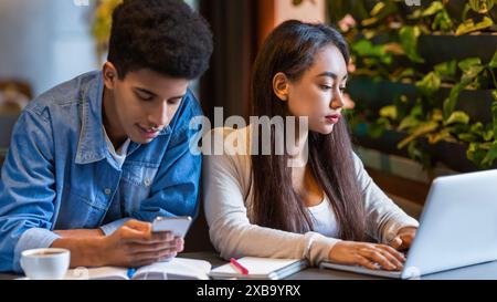 Two Young People Using a Laptop in a Cafe Stock Photo