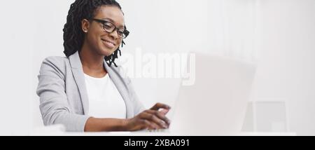 Office employee is focused on her computer at her desk Stock Photo