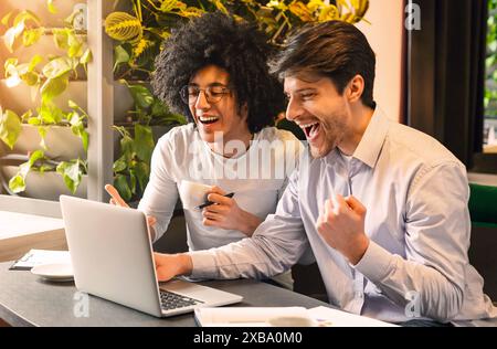 Happy millennial men looking at laptop enjoying great news Stock Photo
