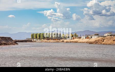 Lac Assal salt lake waters with salt extraction factory in the background, the lowest point of Africa, Tadjourah Region, Djibouti Stock Photo