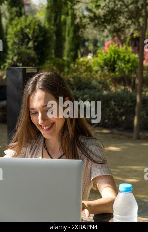 Young student on university campus, concentrating using her laptop. Beginning of classes, academic life, technology, student environment Stock Photo