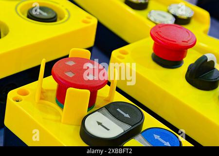 Assorted yellow plastic industrial remotes with buttons and switches, close up shot, selective focus Stock Photo