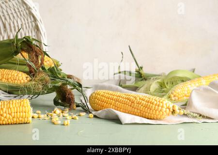 Fresh corn cobs and seeds on green wooden table Stock Photo