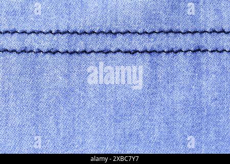 Detail of a blue fabric with a square print. The fabric has two parallel lines sewn on it. Stock Photo