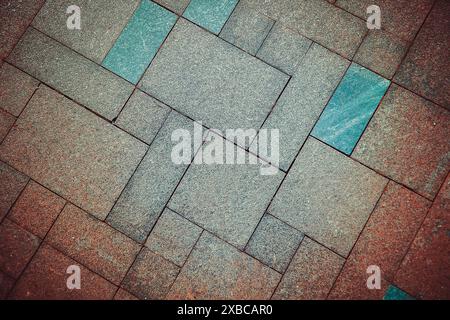 Geometric pattern of pavement tiles in blue and brown tones, creating a textured urban flooring design, background image Stock Photo