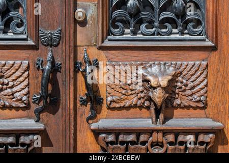 Detail, entrance door with gecko door handles and wood carvings in the shape of birds, Vasaplatsen, Vasastaden, Gothenburg, Vaestra Goetalands laen Stock Photo