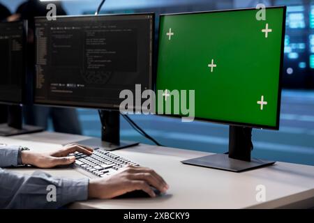 Engineer in server hub using green screen PC to repair equipment storing datasets. Professional using mockup computer to do debugging on rigs doing computational operations Stock Photo