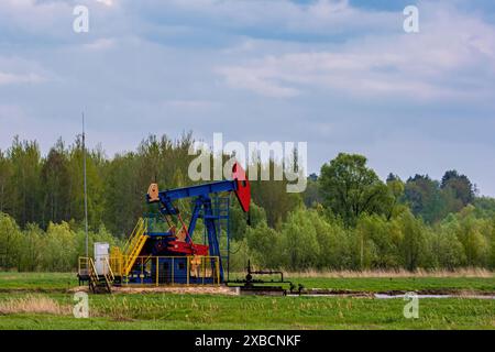 Oil drilling derrick pumps oil from ground. Petroleum industry, crude oil extraction. Production of fuel from natural resources. Oil crisis. Stock Photo